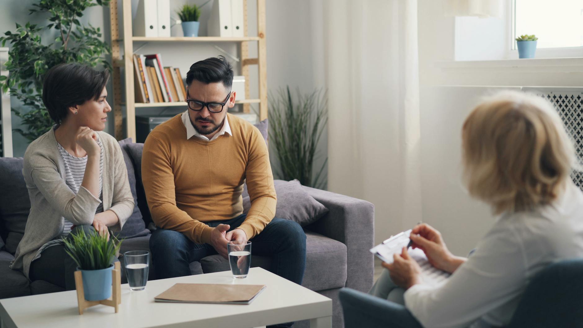 a couple sitting on a couch talking to a therapist